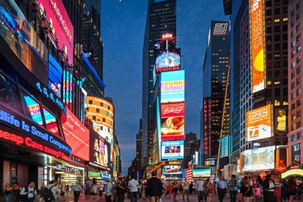 Bright digital billboards and pedestrian plaza in Times Square, New York City, at night.