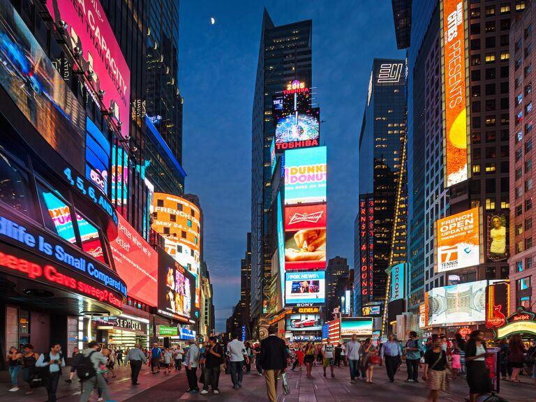 Bright digital billboards and pedestrian plaza in Times Square, New York City, at night.